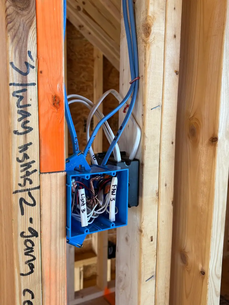 Blue electrical box with wires inside, each labeled by hand